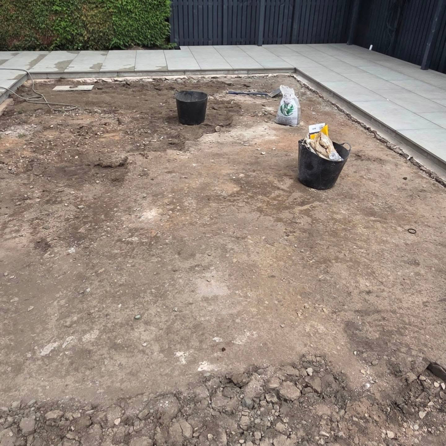 Bare soil between paving in an Eskbank garden before new turf